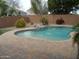 Inviting backyard pool with brick pavers, rock feature, landscaping, and block fence at 10302 E Cicero Cir, Mesa, AZ 85207