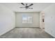 Spacious bedroom featuring neutral carpet, a window, and an ensuite bathroom at 10841 W Nosean Rd, Peoria, AZ 85383