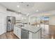 Kitchen view shows stainless appliances, granite countertops, island with wood facade, and open layout at 10841 W Nosean Rd, Peoria, AZ 85383