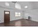 Bright entryway featuring wood floors, white walls, a modern light fixture, and a stylish front door at 11124 W Southern Ave, Tolleson, AZ 85353