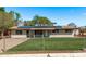 Charming single story home with a well-maintained lawn, secure chain link fence and solar panels on the roof at 11124 W Southern Ave, Tolleson, AZ 85353