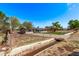 A single story home with desert landscaping, a chain link fence, solar panels, and a convenient culvert at 11124 W Southern Ave, Tolleson, AZ 85353