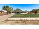 Inviting single-story home featuring a fenced yard, well-kept lawn, and modern solar panels for energy efficiency at 11124 W Southern Ave, Tolleson, AZ 85353