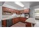 Spacious kitchen with dark wood cabinets and stainless steel appliances, and hardwood floors at 11124 W Southern Ave, Tolleson, AZ 85353