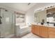 Bright bathroom featuring double sinks, soaking tub, and glass shower at 12787 S 175Th Ave, Goodyear, AZ 85338