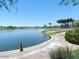 Scenic view of the lake with palm trees, green spaces, and walking paths at 12787 S 175Th Ave, Goodyear, AZ 85338