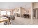 A spacious living room with neutral tones and tile flooring, with views of the dining room and kitchen at 12787 S 175Th Ave, Goodyear, AZ 85338