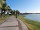 Scenic walking path near a lake, lined with palm trees and offering picturesque views at 12787 S 175Th Ave, Goodyear, AZ 85338