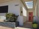 Inviting front entrance with a bright orange door, white brick, sleek lighting and an open pergola at 12807 N 21St Dr, Phoenix, AZ 85029