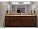 Bathroom featuring double vanity, granite countertop, wooden cabinets and modern lighting fixtures at 12809 N 50Th St, Scottsdale, AZ 85254