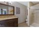 Bathroom with a vanity, granite countertop, wood cabinets, and glass shower enclosure at 12809 N 50Th St, Scottsdale, AZ 85254