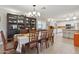 Bright dining room boasts tile flooring, stylish chandelier, dark cabinet, and access to the kitchen at 12809 N 50Th St, Scottsdale, AZ 85254