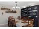 Dining area with a large table, chairs, hutch, wood shelving, and modern lighting at 12809 N 50Th St, Scottsdale, AZ 85254