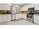 Well-lit kitchen features stainless steel appliances, granite countertops, and white cabinets at 12809 N 50Th St, Scottsdale, AZ 85254