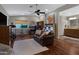 Spacious living room with hardwood floors, a cozy couch, and adjacent work and bathroom areas at 12809 N 50Th St, Scottsdale, AZ 85254