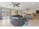 Comfortable living room featuring a leather sectional sofa, tiled floors, and sliding glass doors to the patio at 12809 N 50Th St, Scottsdale, AZ 85254