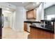 Kitchen area showcasing granite countertops, stainless steel sink, and tan tile flooring creating a clean aesthetic at 14575 W Mountain View Blvd # 925, Surprise, AZ 85374