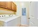 Functional laundry room features a washer, dryer, upper cabinets, and easy access with a nearby door at 14575 W Mountain View Blvd # 925, Surprise, AZ 85374