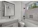 Modern bathroom with a gray vanity, black hardware, and white tiled tub and shower combo at 16706 N 109Th Way, Scottsdale, AZ 85255