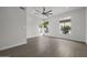 Bright bedroom with wood floors, ceiling fan, and large windows offering natural light and outdoor views at 16706 N 109Th Way, Scottsdale, AZ 85255