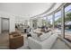 Open-plan living room with modern furnishings, hardwood floors, and beautiful outdoor views of pool and greenery at 16706 N 109Th Way, Scottsdale, AZ 85255
