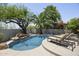 Relaxing pool area with lounge chairs, a rock waterfall feature, and a beautifully landscaped yard at 16706 N 109Th Way, Scottsdale, AZ 85255