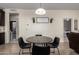 Dining area with a modern table, comfortable seating, and view into the living room and hallway at 17308 W Daley Ln, Surprise, AZ 85387