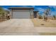 Single story home with a two-car garage, stone accents and desert landscaping at 17308 W Daley Ln, Surprise, AZ 85387