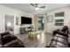 Cozy living room featuring a ceiling fan, tile floors, and a sliding glass door to the backyard at 17308 W Daley Ln, Surprise, AZ 85387