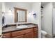 Bathroom features a sink with a dark countertop, vanity, mirror, and modern lighting at 18440 N 43Rd Dr, Glendale, AZ 85308