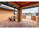 Covered patio area with patterned brick, a stone table, and a relaxing outdoor space at 18440 N 43Rd Dr, Glendale, AZ 85308