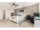 Bedroom features a decorative bed frame, ceiling fan, and a window and nearby desk at 19137 W Pasadena Ave, Litchfield Park, AZ 85340