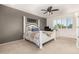 Bedroom features a decorative bed frame, ceiling fan, and a window with shutters and nearby desk at 19137 W Pasadena Ave, Litchfield Park, AZ 85340