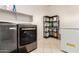 Well-organized laundry room featuring a front load washer and dryer, shelving and ample storage space at 19137 W Pasadena Ave, Litchfield Park, AZ 85340