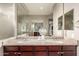 Bathroom vanity with double sinks, granite countertop, wood cabinets, and a large mirror at 19675 E Oriole Way, Queen Creek, AZ 85142