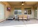 Relaxing covered patio with a dining table, ceiling fan, and TV creating an inviting outdoor space at 19675 E Oriole Way, Queen Creek, AZ 85142