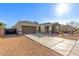 Single-story home featuring a three-car garage, desert landscaping, and a long driveway at 19675 E Oriole Way, Queen Creek, AZ 85142