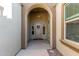 Arched front porch with a decorative wreath on the front door and sidelight windows at 19675 E Oriole Way, Queen Creek, AZ 85142