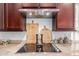 Close-up of a kitchen featuring a sleek stovetop, modern range hood, and stylish decor at 19675 E Oriole Way, Queen Creek, AZ 85142