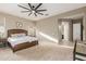 Bright main bedroom with ceiling fan, wood headboard, and ensuite bathroom at 19675 E Oriole Way, Queen Creek, AZ 85142