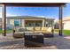 Covered patio with wicker sofa seating around a fire pit, creating a cozy outdoor lounge area at 19675 E Oriole Way, Queen Creek, AZ 85142