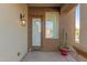 Side entry featuring a glass door and sidelight, illuminated by an outdoor lantern at 19675 E Oriole Way, Queen Creek, AZ 85142