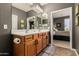 The stylish bathroom features double sinks, wooden cabinets, and tile flooring, with the main bedroom through doorway at 208 W Lantern Way, San Tan Valley, AZ 85143