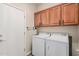 Laundry room with a white washer and dryer and lots of wooden cabinets above at 208 W Lantern Way, San Tan Valley, AZ 85143