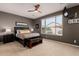 Spacious main bedroom features soft carpet, ceiling fan, and a large window allowing natural light at 208 W Lantern Way, San Tan Valley, AZ 85143