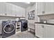 Well-organized laundry room with modern washer, dryer, cabinetry and attractive decor accents at 20846 E Longwood Dr, Queen Creek, AZ 85142