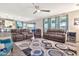 The large living room features gray sofas and an accent chair arranged on a stylish geometric carpet at 20846 E Longwood Dr, Queen Creek, AZ 85142