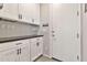 Stylish mudroom with white cabinets, dark countertops, wine glass rack, and convenient key hooks near the door at 20846 E Longwood Dr, Queen Creek, AZ 85142