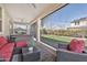 Relaxing covered patio with comfortable red cushioned seating, ceiling fan, and views of the lush backyard at 20846 E Longwood Dr, Queen Creek, AZ 85142