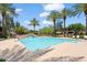 A full view of the community pool, equipped with lounge chairs and surrounding palm trees at 21320 N 56Th St # 2005, Phoenix, AZ 85054